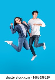 Young Asian Couple Man And Woman Jumping With Happy And Fun Over Blue Background