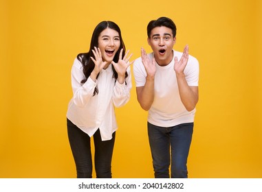 Young Asian Couple Man And Woman Happy And Shout Announce On Yellow Background.	