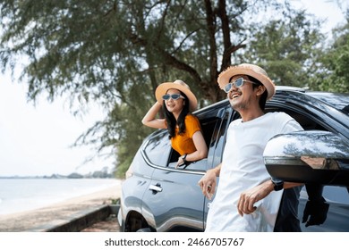 Young asian couple man and woman travel by car on a bright day to the sea sand beach with beautiful blue sky sunlight. They was happy along the way trip. safety driving car vacation. - Powered by Shutterstock