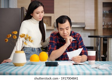 Young Asian Couple Managing Home Finances, Checking Monthly Taxes, Credit Card Payment Bills And Utility Bills