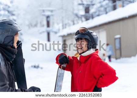 Young Asian couple practicing freeride snowboard and ski on snowy mountain at ski resort. Man and woman enjoy outdoor activity active lifestyle winter extreme sport training on holiday travel vacation