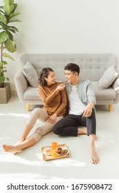 Young Asian Couple Relaxing At Home