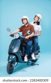 Young Asian couple ride scooter on background - Shutterstock ID 2283400309