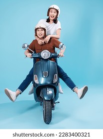Young Asian couple ride scooter on background - Shutterstock ID 2283400321