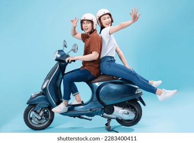 Young Asian couple ride scooter on background - Shutterstock ID 2283400411