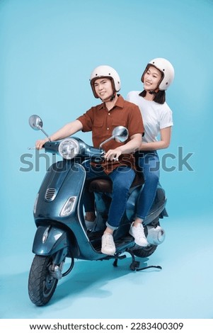 Young Asian couple ride scooter on background