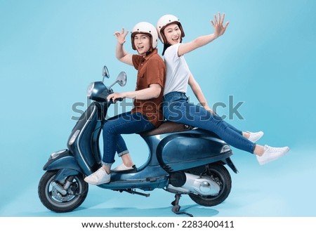 Young Asian couple ride scooter on background