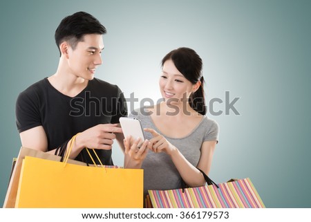 young Asian couple shopping and looking at cellphone 