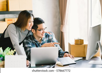 Young Asian Couple Startup Family Business, Online Marketing Packaging And Delivery Scene. SME Entrepreneur, Business Partner, Or Freelance Work At Home Concept.