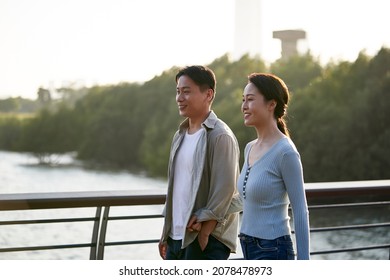 Young Asian Couple Taking A Walk In City Park