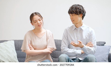 Young Asian Couple Talking In The Living Room