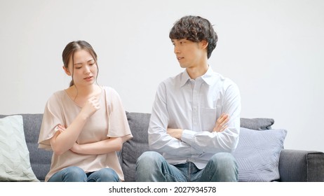 Young Asian Couple Talking In The Living Room