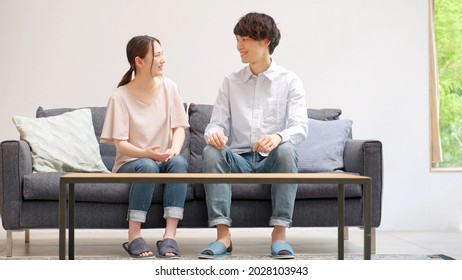 Young Asian Couple Talking In The Living Room