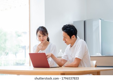 Young Asian couple thinking in front of a computer