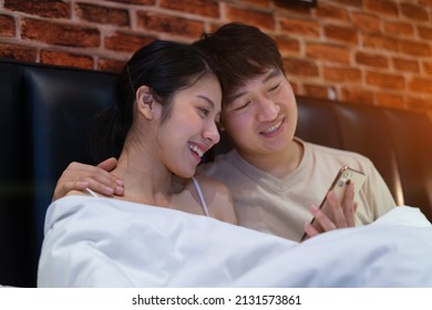 Young Asian Couple Using Smartphone At Night