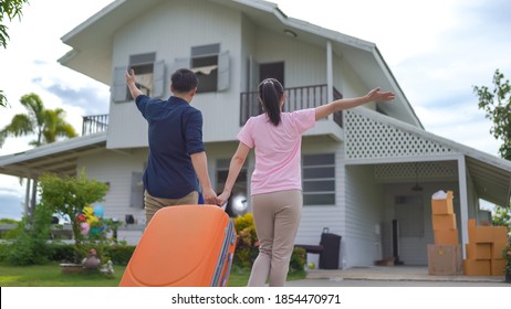 Young Asian Couple Walking In To Front Of Their New House