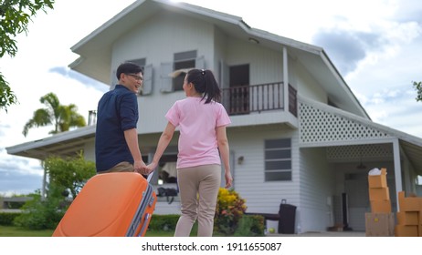 Young Asian Couple Walking In To Front Of Their New House