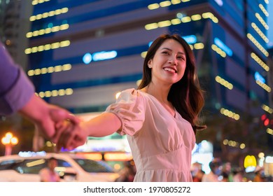 Young Asian Couple Walking On The Street At Night