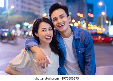 Young Asian couple walking on the street at night