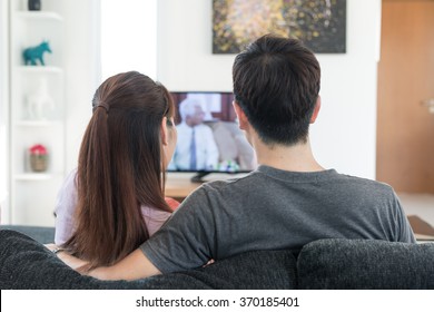 Young Asian Couple Watching Movie On Tv At Home.