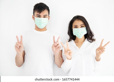 Young Asian Couple Wearing Surgical Mask Over White Background, Healthcare And Infection Control Concept.