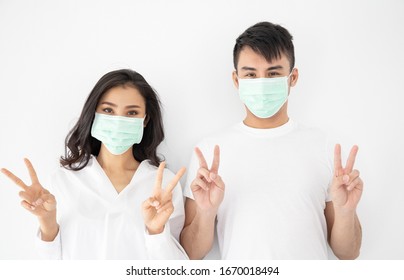 Young Asian Couple Wearing Surgical Mask Over White Background, 