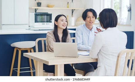 Young Asian Couple And Woman Meeting In The Modern House. Real Estate Agent.