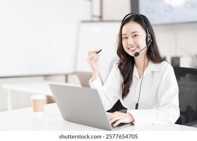 Young Asian Customer service representative using a headset while working at a call center