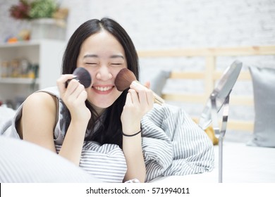 Young Asian Cute Woman Make Up Her Clear And Pure Face On Her Bed In The Bedroom With Smile And Happy Mood (shallow Depth Of Field)