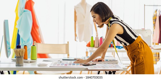 Young Asian Designer Woman Working With Computer And Choosing Multicolor Chart At Workplace, Small Business Startup, Business Owner Entrepreneur, Modern Freelance Job Lifestyle Concept. Asean People