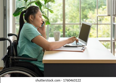 Young Asian Disabled Woman Using Computer And Smartphone To Work In The Office. Disability And Handicapped Concept