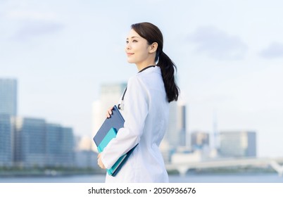 Young Asian Doctor Smiling In Front Of The City.