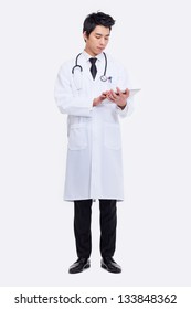 Young Asian doctor using tabet pc isolated on white background.