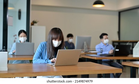 Young Asian Employee With Face Masks In The Office After Lockdown, New Normal And Return To Work Concept