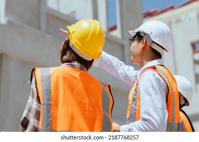 Young Asian Engineers On The Construction Site Are Discussing Building A House In The Hot Sun.