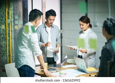 Young Asian Entrepreneurs Of Small Company Discussing Business Plan In Office Meeting Room.