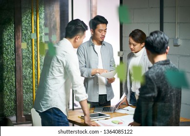 Young Asian Entrepreneurs Of Small Company Discussing Business Plan In Office Meeting Room.