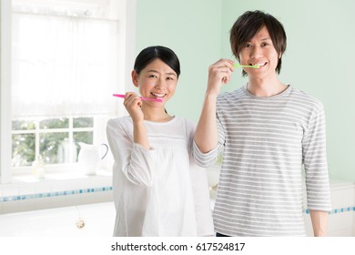 Young Asian Family Brushing Tooth