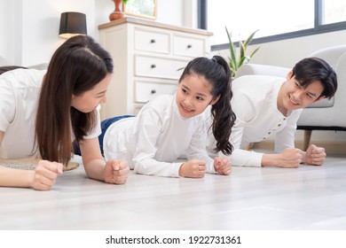 Young Asian Family Doing Exercise Together At Home
