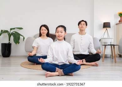 Young Asian family doing exercise together at home
