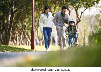 young asian family enjoying outdoor activity in city park