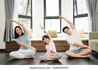 Young Asian family exercise at home - Powered by Shutterstock