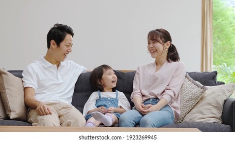 Young Asian Family Talking In The Living Room