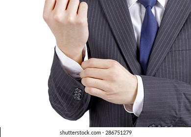 Young asian fashion man looking at his cufflinks while fixing them