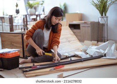 Young Asian Female Assembling Furniture On Her Own