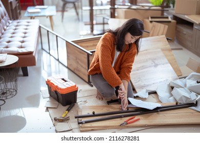 Young Asian Female Assembling Furniture On Her Own