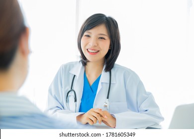 Young Asian Female Doctor Talking With Her Client 