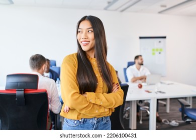 Young Asian Female Entrepreneur Standing At Coworking Office. Portrait Of Smiling Businesswoman In Startup Office