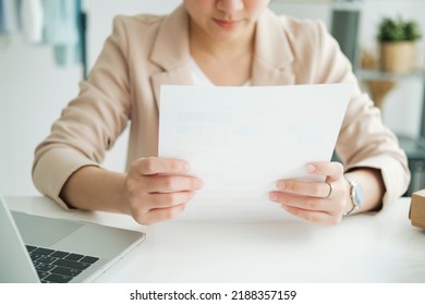 Young asian female freelan sit reading report on paper in online clothing store.Work at home concept. work from home. - Shutterstock ID 2188357159