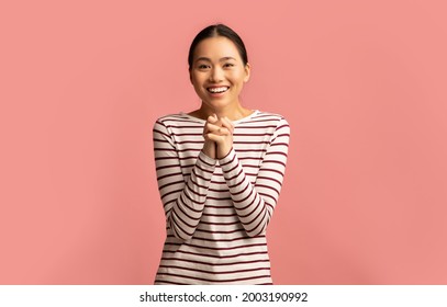 Young asian female pleading and asking for something with clasped hands, excited emotional korean lady looking at camera and saying please while standing isolated over pink background, copy space - Shutterstock ID 2003190992